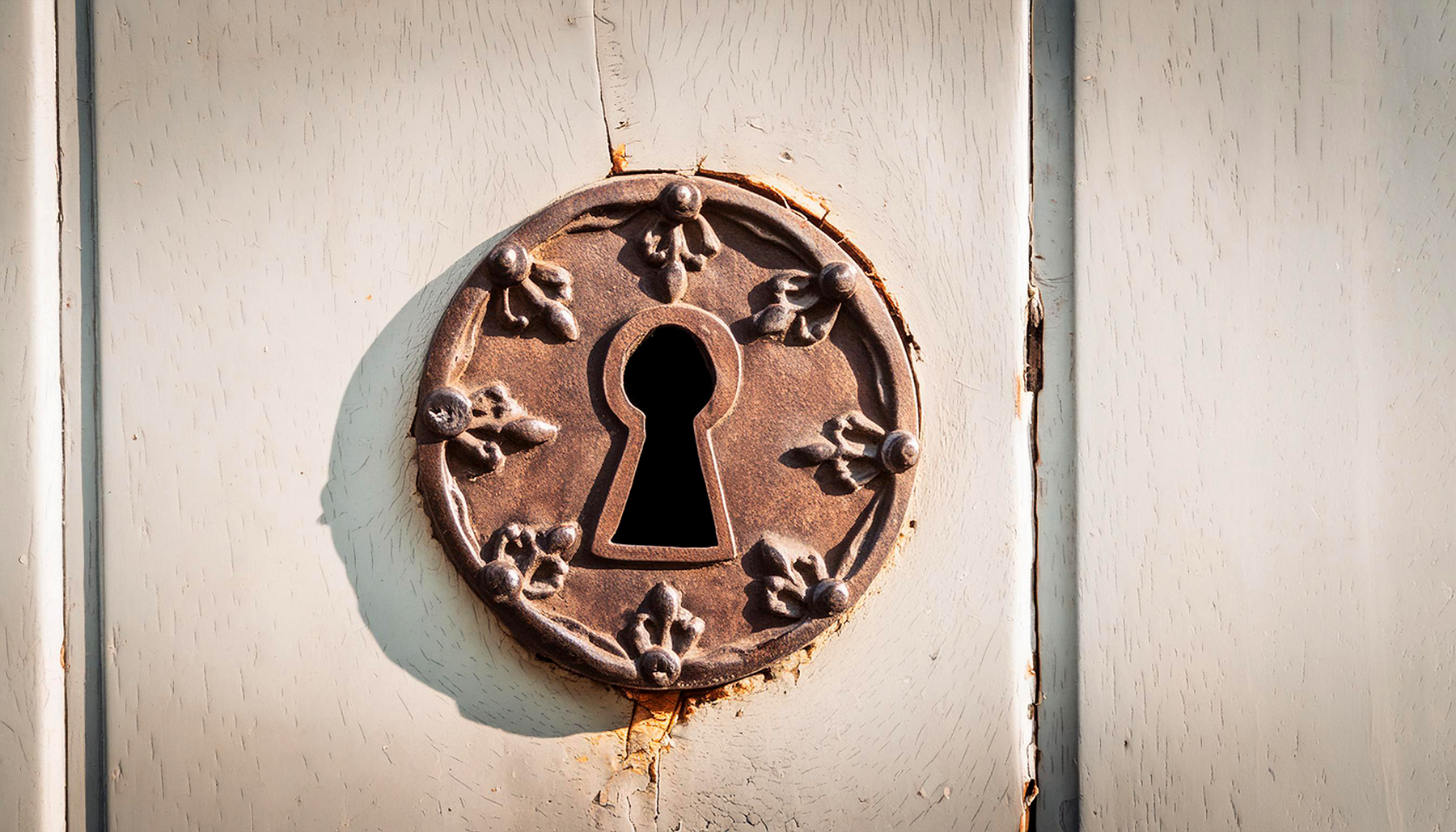 Photo of a rusty keyhole in an old wooden door